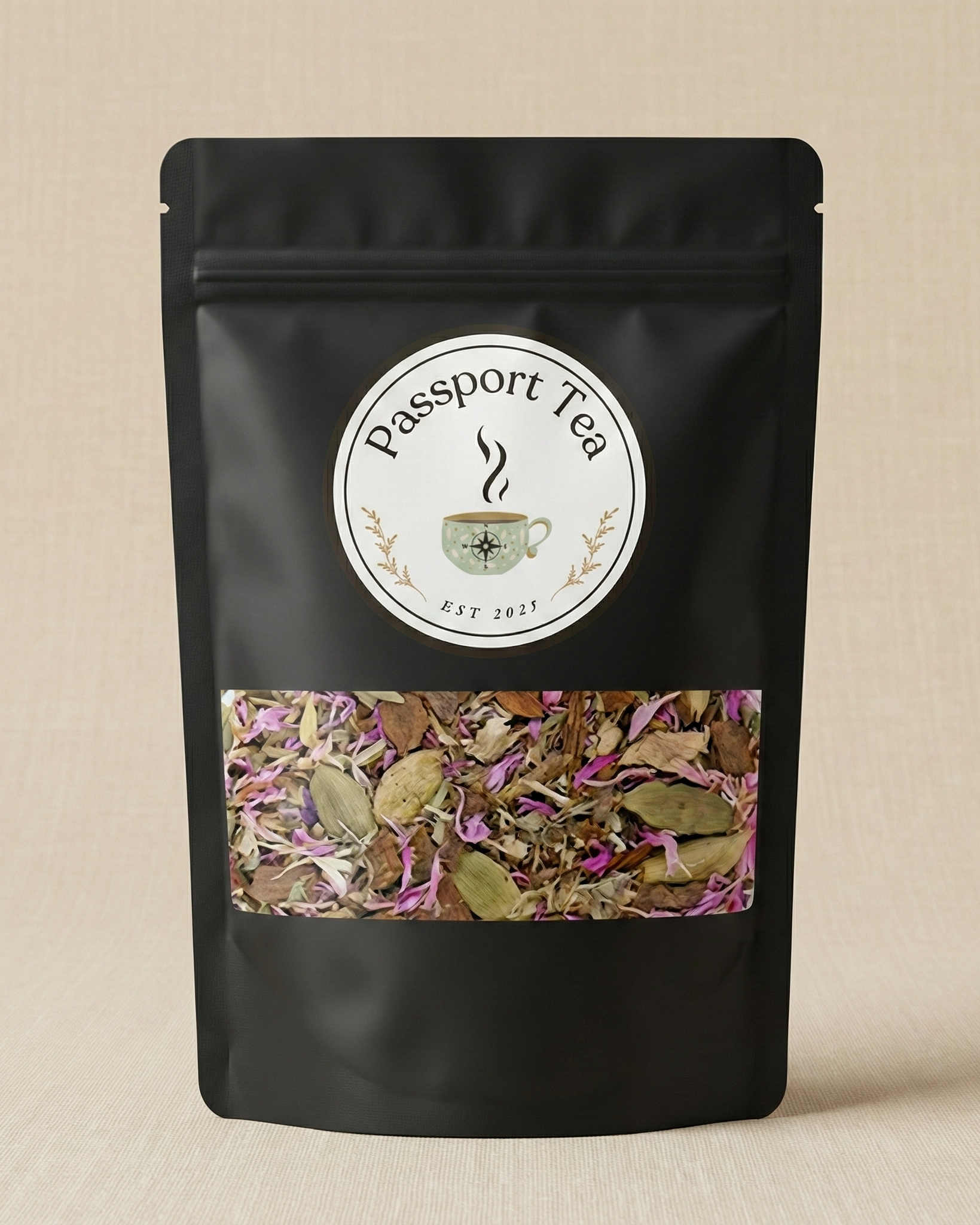 Black tea packaging with 'Passport Tea' label and visible tea leaves on a beige background